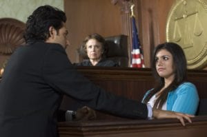 A lawyer questioning a witness in front of a judge in a courtroom