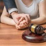 Man holding a woman's hand with a gavel in front of them