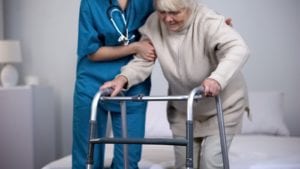 Nurse assisting a patient using a walker