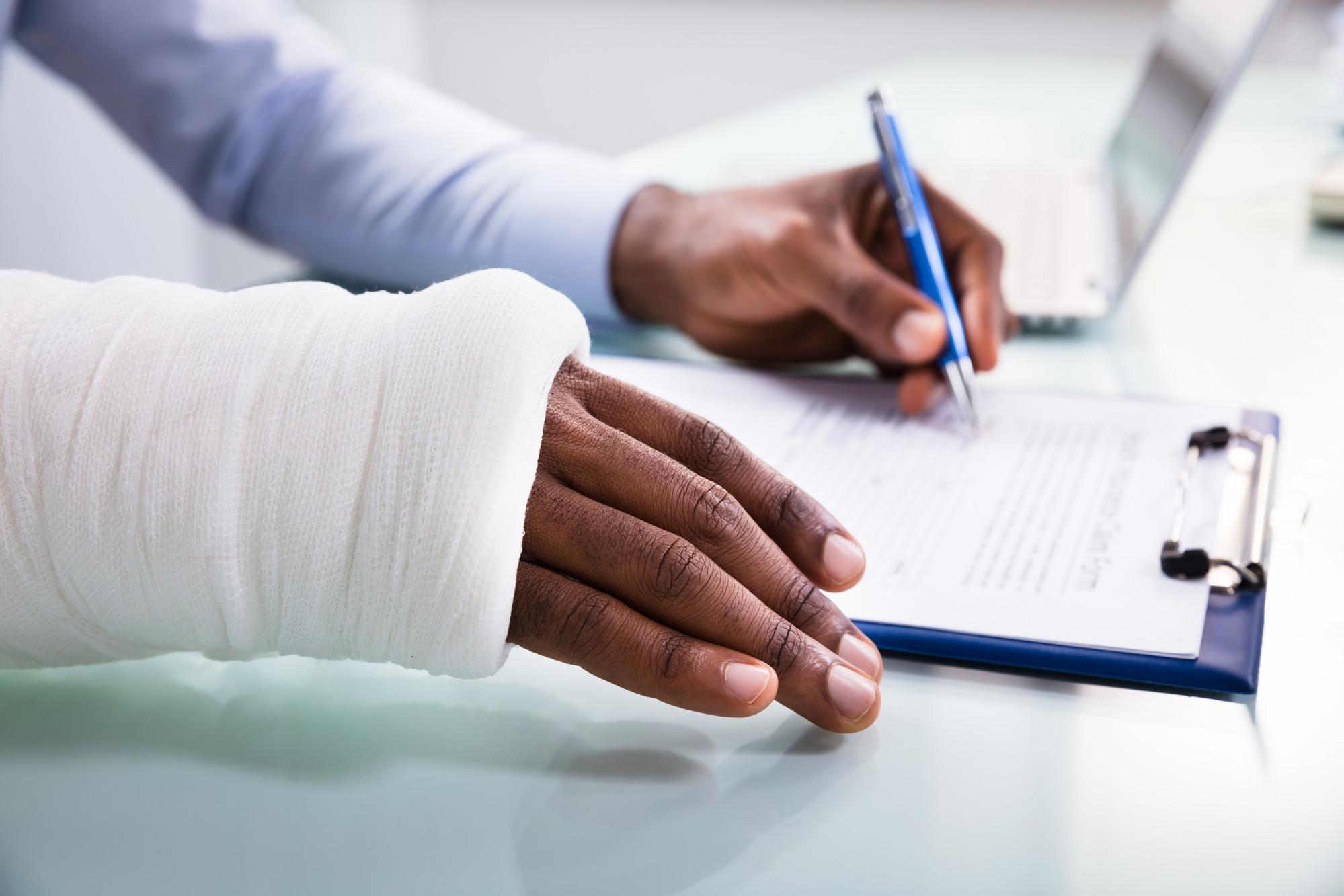 Injured man filling out an insurance claim form