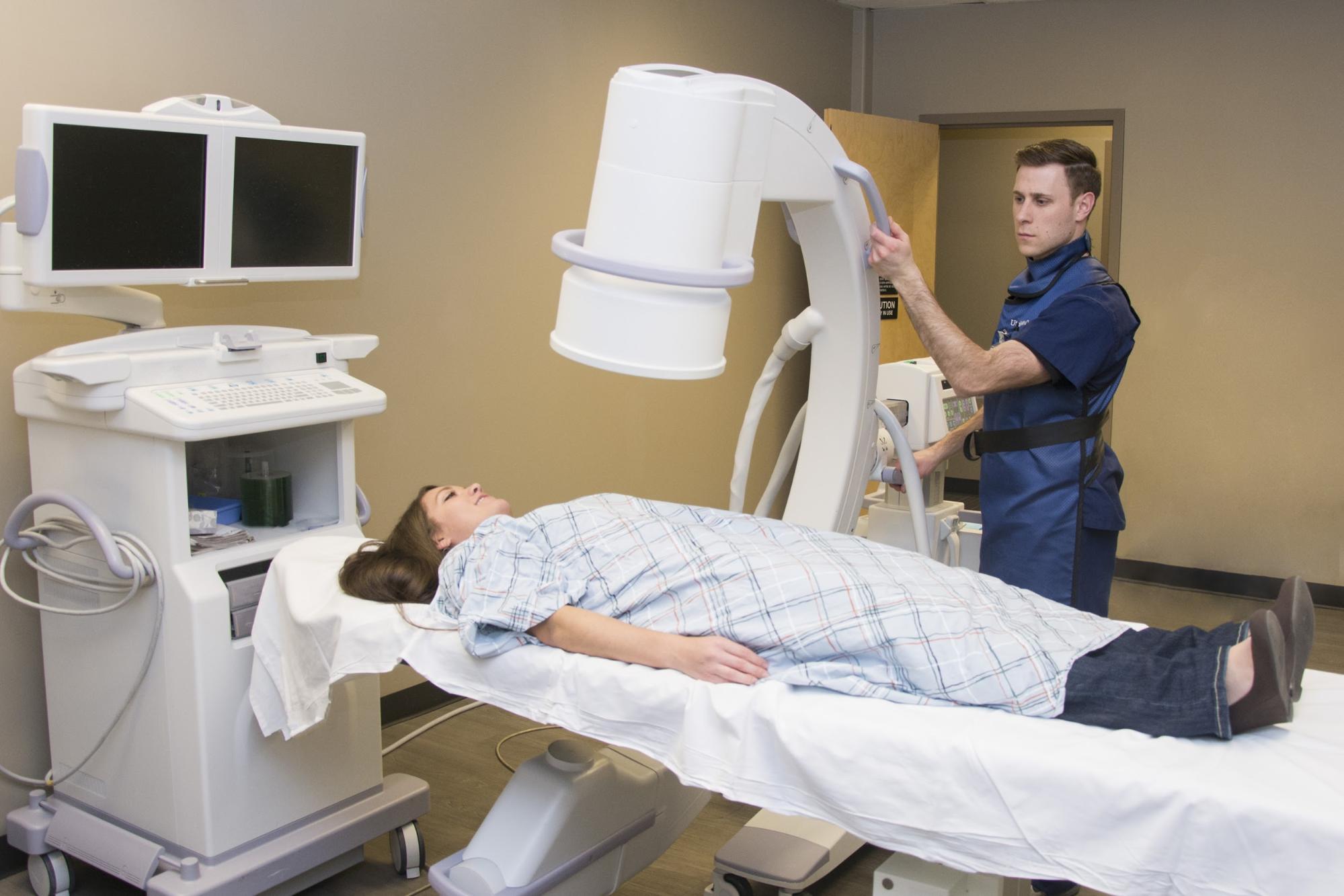 Radiology technician doing an X-ray test on a patient